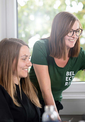 Employee shows a colleague the BELECTRIC Compliance Guideline digitally on a laptop