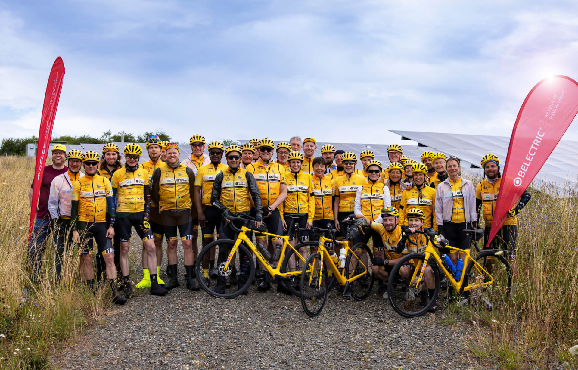 The cycling Team Rynkeby Berlin stands in front of BELECTRIC's solar farm in Reddehausen.