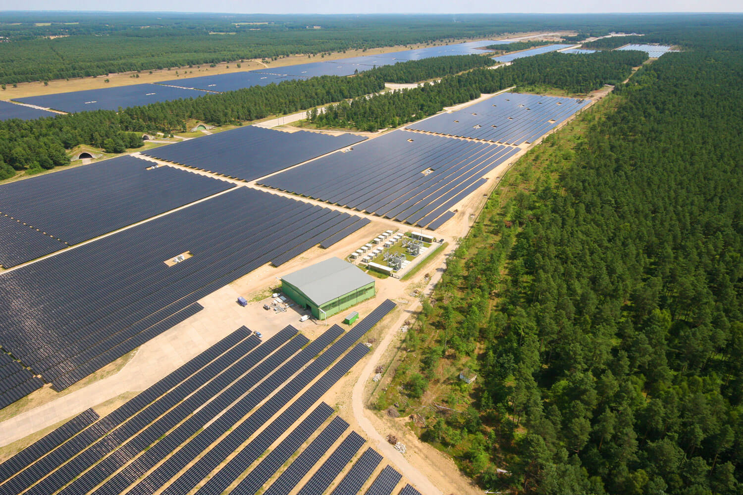 BELECTRIC's large-scale photovoltaic plant in Templin, Germany, seen from above in the midst of a forest